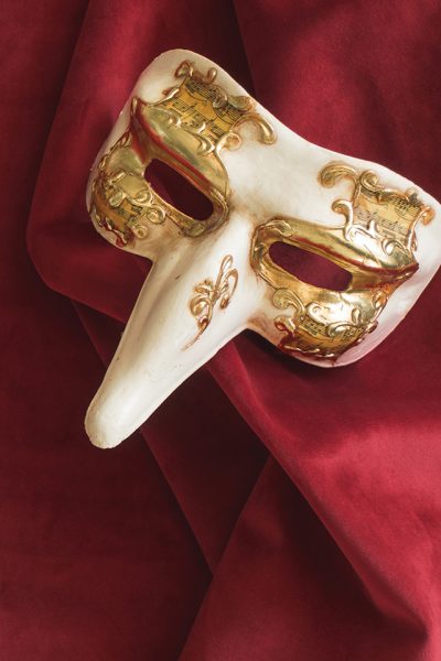 venetian-mask-with-long-se-on-red-fabric
